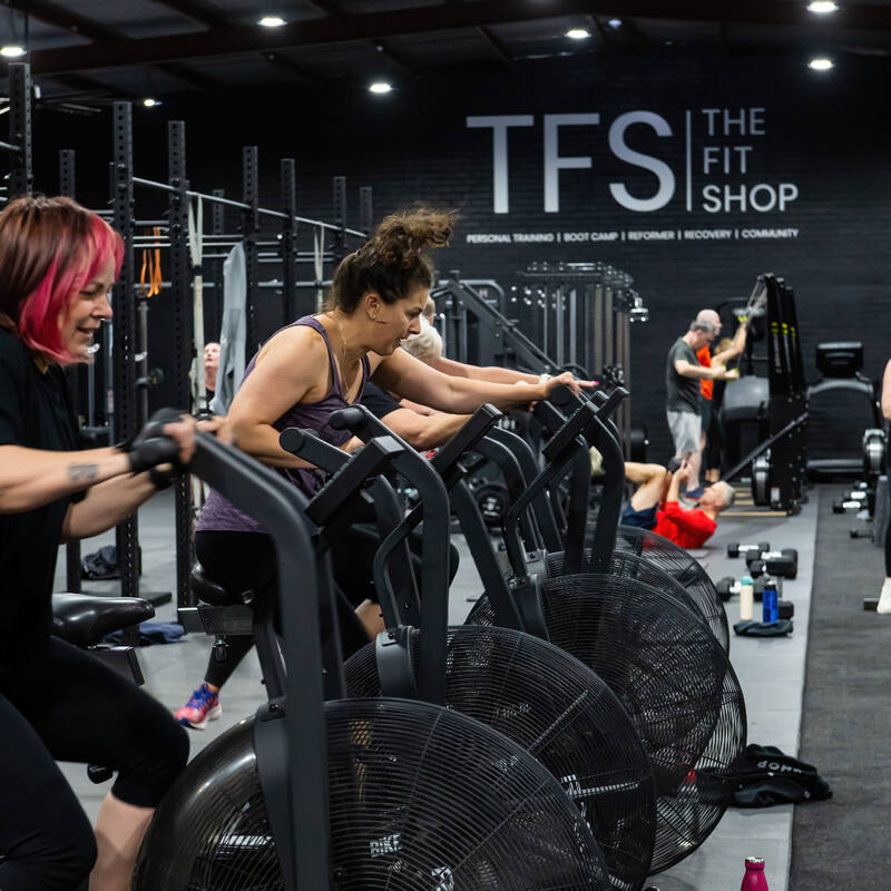 Members training on bikes and rowers together