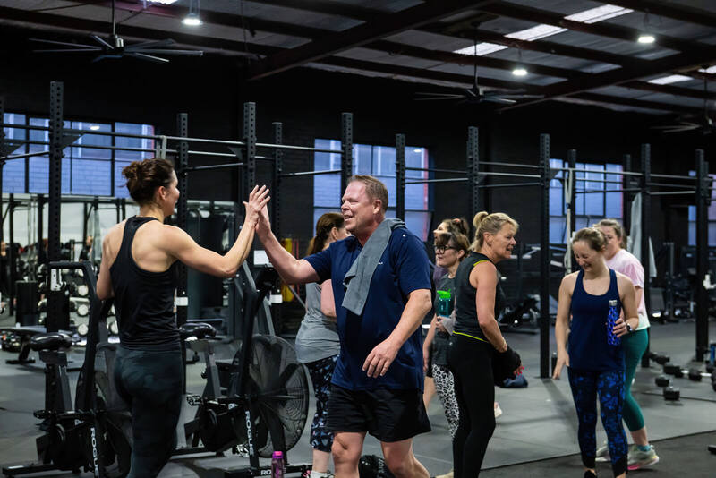 Members high-fiving and laughing after a session