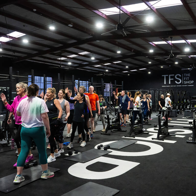 Members walking and chatting across the gym floor